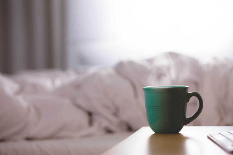 A green cup beside a softly lit window