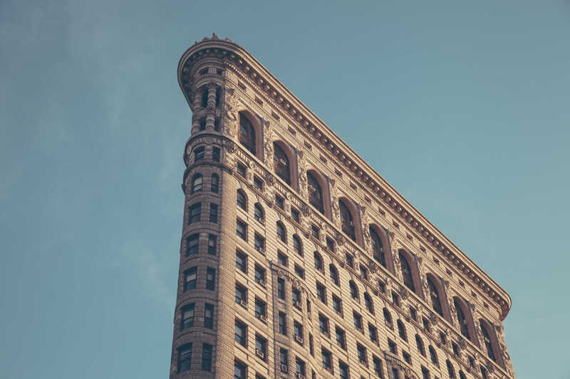 An ornate wedge-shaped building against a clear sky