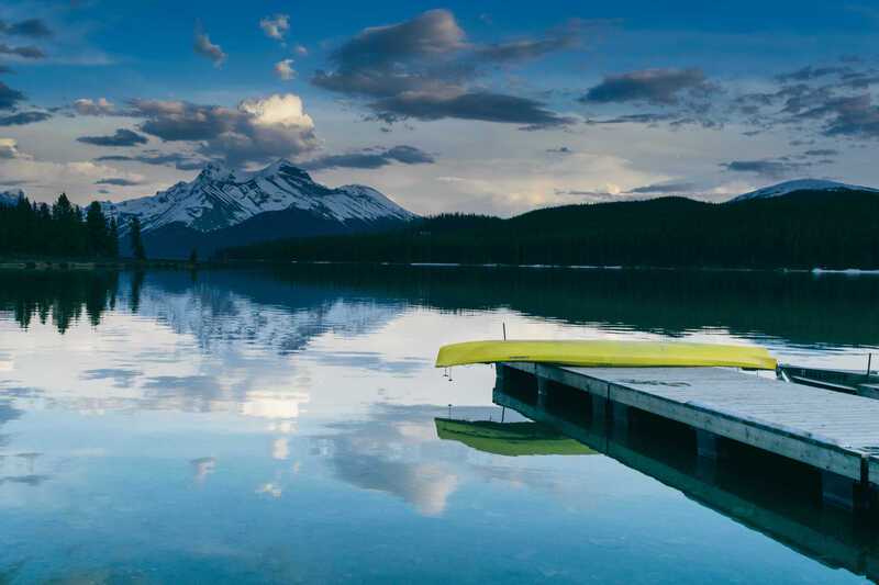 A yellow canoe beside a calm mountain lake
